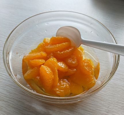 Segments de mandarine en conserve de la récolte 2025 avec des oranges fraîches jaune doré, prêtes à consommer