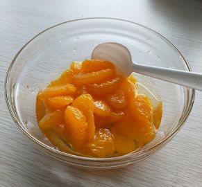 Segments de mandarine en conserve de la récolte 2025 avec des oranges fraîches jaune doré, prêtes à consommer